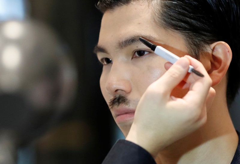 Model Masafumi is made up by make-up artist Hiroki using Pola Orbis subsidiary Acro's cosmetics during their demonstration at a department store in Tokyo