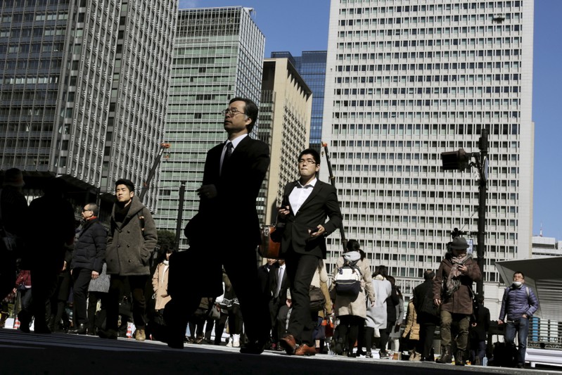 FILE PHOTO: eople cross a street in a business district in Tokyo