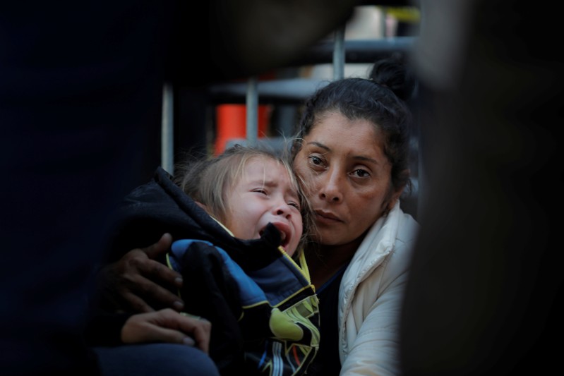 Maria Meza, a 40-year-old migrant woman from Honduras, part of a caravan of thousands from Central America trying to reach the United States, holds her daughter as she waits at the Otay Mesa port of entry in San Diego, California