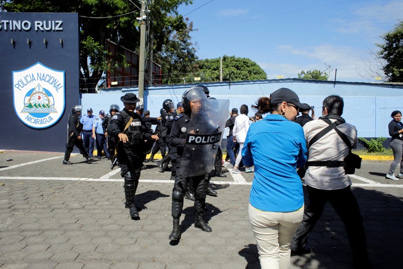 Riot police dislodges journalists from the main entrance of police headquarters in Managua
