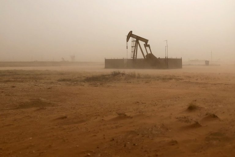 Oil prices slide on swelling U.S. supply, global market slump