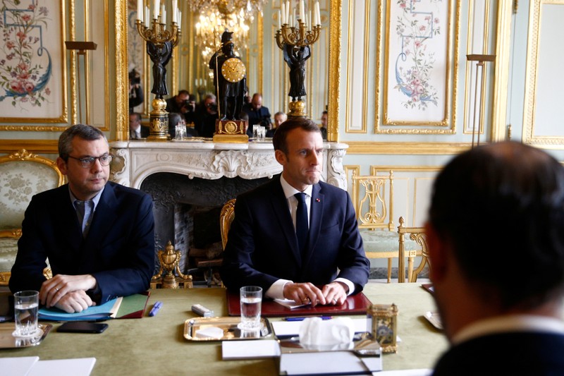 French President Emmanuel Macron sits across from Prime Minister Edouard Philippe at the start of a meeting at the Elysee Palace day after clashes between police and yellow vest protesters, in Paris