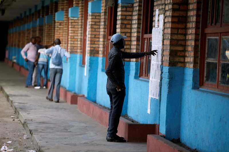A man searches for his name on a voters registrations list at a polling station in Kinshasa