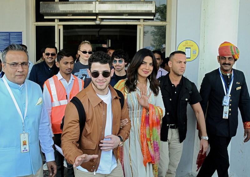 FILE PHOTO: Bollywood actress Priyanka Chopra and singer Nick Jonas wave as they arrive at the airport in Jodhpur
