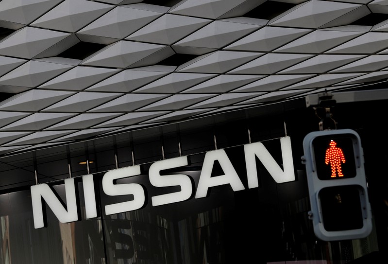 Nissan's signboard is seen behind a traffic sign at its showroom in Tokyo