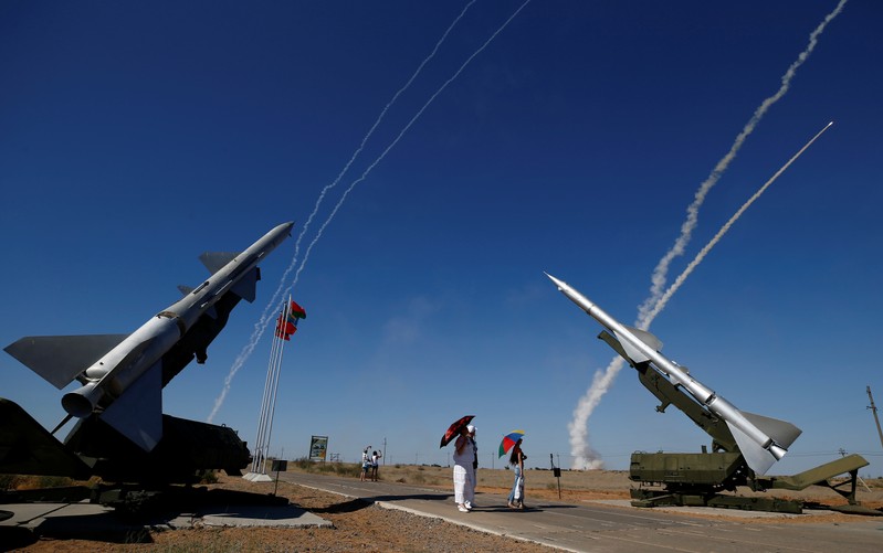 People watch S-300 air defense missile systems launching missiles during the Keys to the Sky competition at the International Army Games 2017 at the Ashuluk shooting range outside Astrakhan