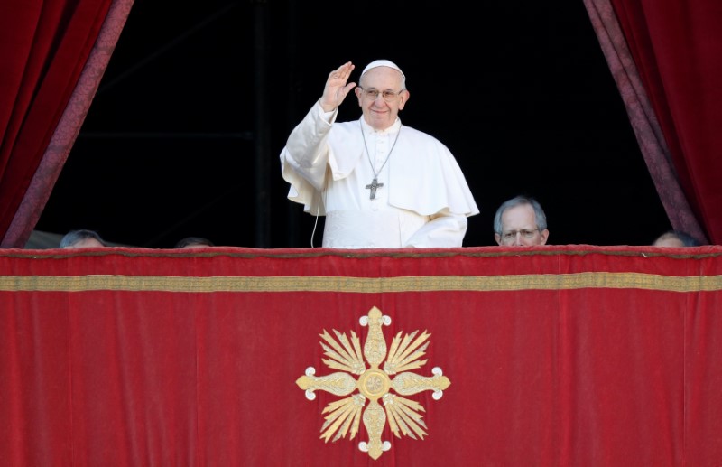 Pope Francis waves as he arrives to deliver the 