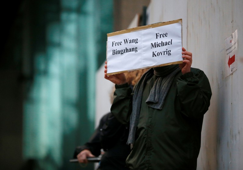 A man holds a sign calling for China to release Wang and former Canadian diplomat Kovrig t the B.C. Supreme Court bail hearing of Huawei CFO Meng in Vancouver