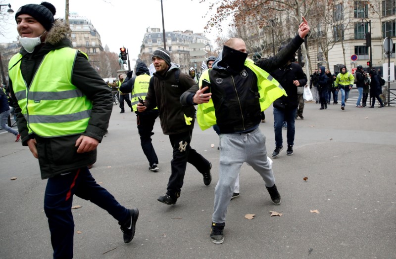 Protesters wearing yellow vests take part in a demonstration by the 