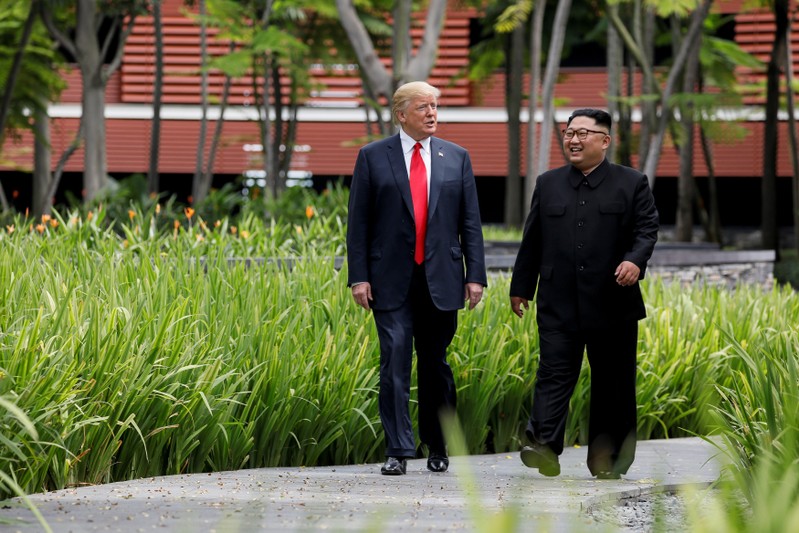 FILE PHOTO: U.S. President Trump and North Korea's Kim walk together before their working lunch during their summit in Singapore