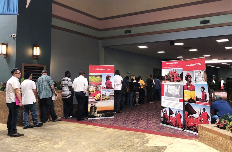 FILE PHOTO - Job seekers line up at a job fair of an oil services giant Halliburton at the MCM Grande Fundome hotel in Odessa Texas