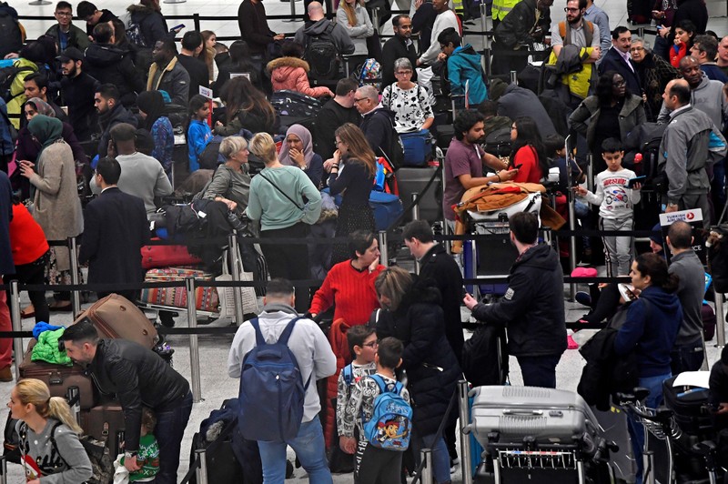 Passengers wait in the queue for check-in in the South Terminal building at Gatwick Airport, after the airport reopened to flights following its forced closure because of drone activity, in Gatwick