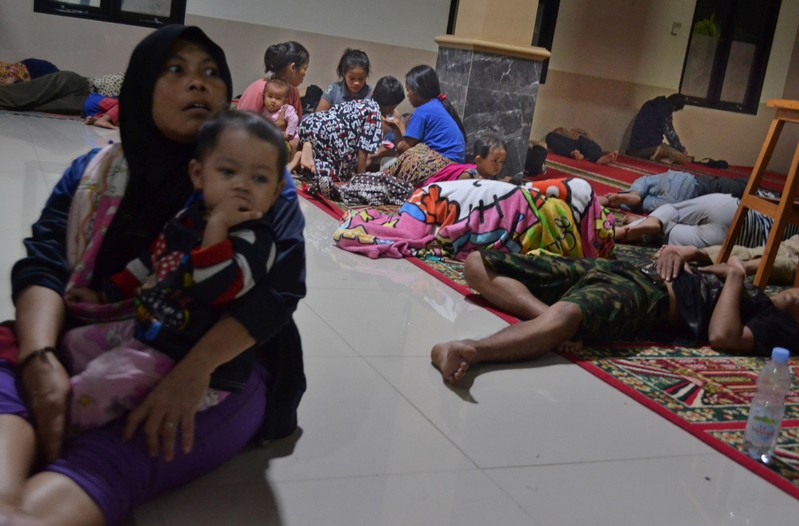 Residents sit inside a mosque as they evacuated following high waves and the eruption of Anak Krakatau volcano at Labuan district in Pandeglang regency