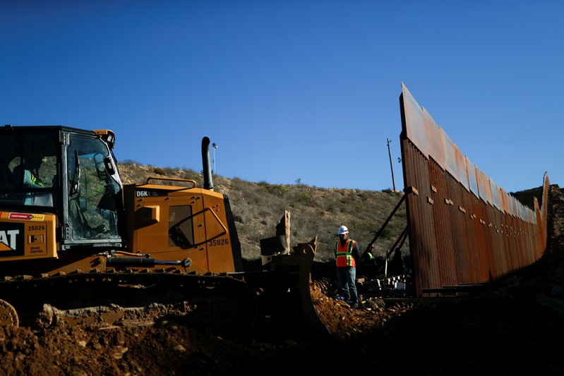 Workers on the U.S. side, work on the border wall between Mexico and the U.S., as seen from Tijuana