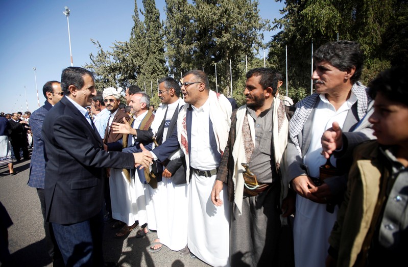 Members of the Houthi delegation participating in the peace talks in Sweden shake hands with their supporters at Sanaa airport, Sanaa
