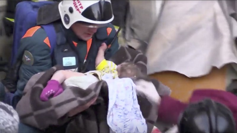 A still image taken from a video footage showsaA rescuer carries a 11-month-old child found alive in the rubble of a Russian apartment block that partially collapsed after a suspected gas blast in Magnitogorsk