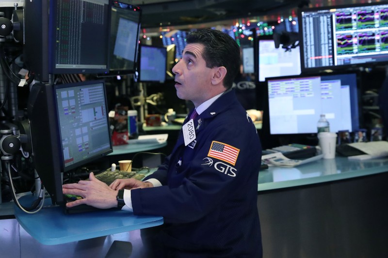 A trader looks at price monitors as he works on the floor at the New York Stock Exchange (NYSE) in New York City, New York