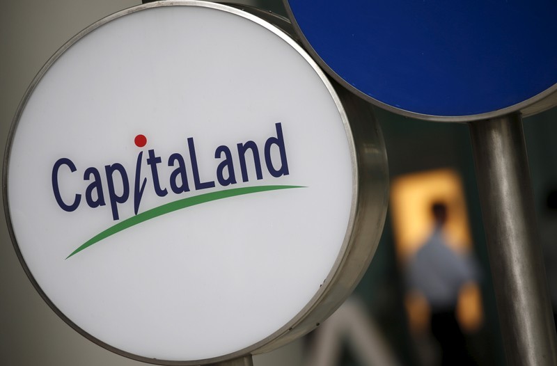 A man passes a Capitaland logo outside an office building in the central business district in Singapore