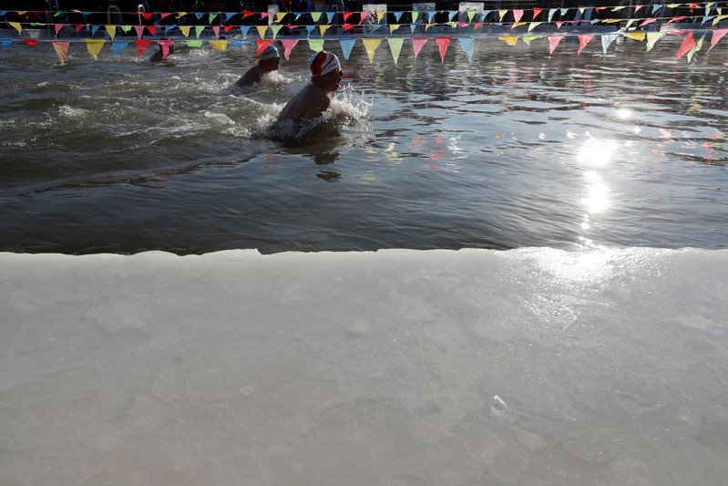 Participants swim in a pool carved out of the frozen Songhua River during an ice swimming competition as a part of the annual ice festival, in the northern city of Harbin