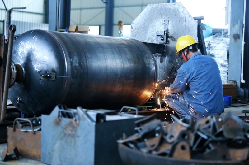 Worker welds a pressure vessel at a company manufacturing industrial equipment in Nantong