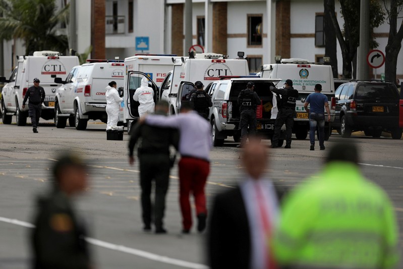 Police and security personnel work at the scene where a car bomb exploded, according to authorities, in Bogota