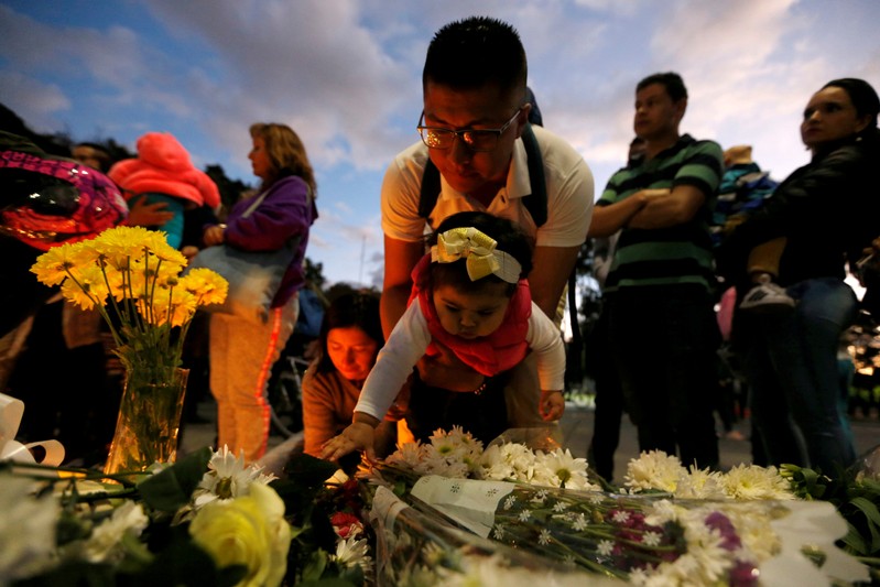 FILE PHOTO: People take part in a candlelight vigil for victims, near the scene of a car bomb explosion, in Bogota