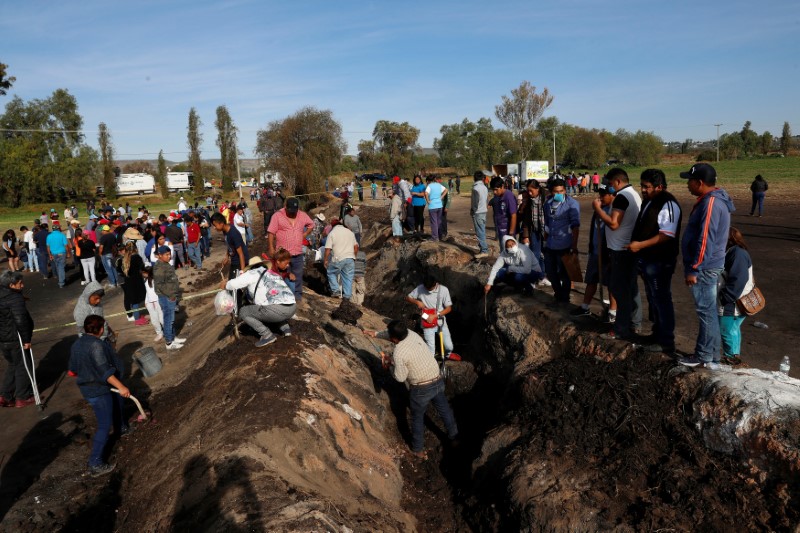 Residents search for human remains and items that could help to identify their missing relatives and friends at the site where a pipeline ruptured by oil thieves exploded, in the municipality of Tlahuelilpan