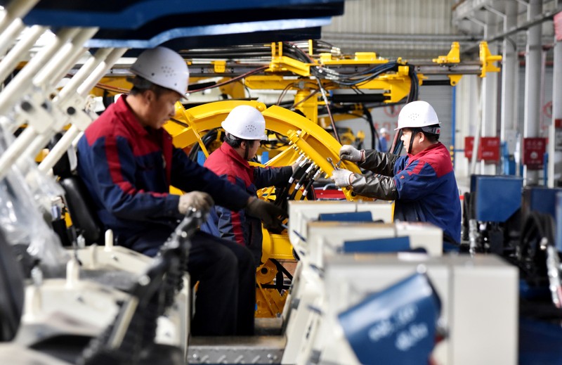 FILE PHOTO: Employees work on a drilling machine production line at a factory in Zhangjiakou