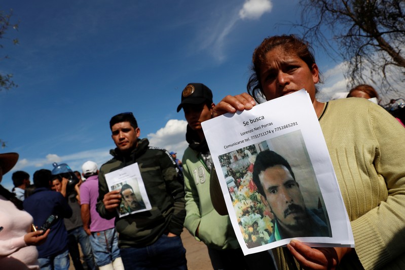 Residents hold pictures of their missing relative at the site where a fuel pipeline ruptured by suspected oil thieves exploded, in the municipality of Tlahuelilpan, state of Hidalgo