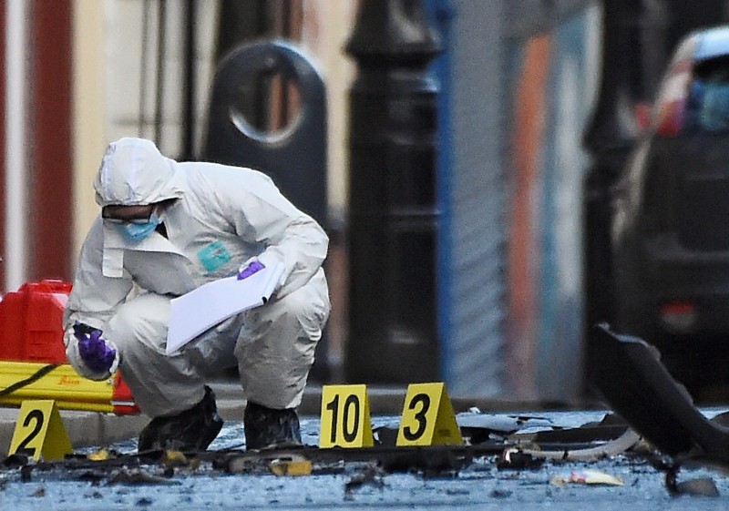 Forensic officer inspects the scene of a suspected car bomb in Londonderry