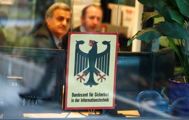 FILE PHOTO: Security personnel sits behind the bullet-proof window at the headquarters of Germany's BSI national cyber defence body in Bonn