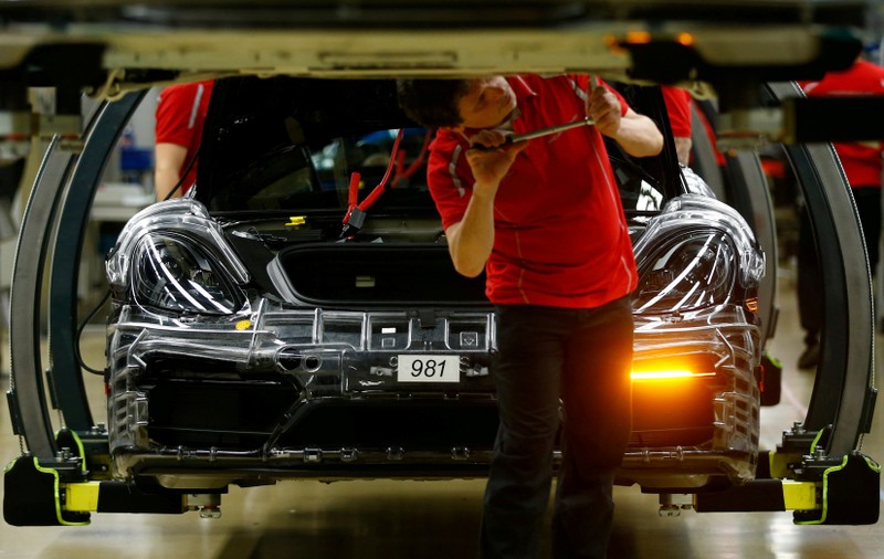 FILE PHOTO: An employee of German car manufacturer Porsche works at the Porsche factory in Stuttgart-Zuffenhausen