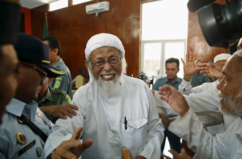 Indonesian radical Muslim cleric Abu Bakar Bashir greets supporters inside a courtroom following the first day of an appeal hearing in Cilacap, Central Java province