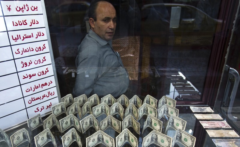 FILE PHOTO: An exchange currency dealer sits at his shop as he waits for customer in Tehran's business district
