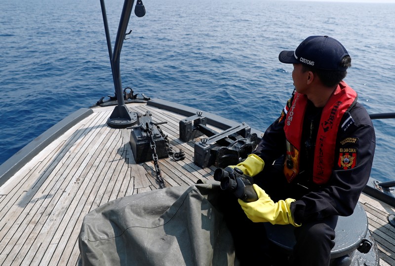Indonesian customs officers patrol at a search area for Lion Air flight JT610 in Karawang waters