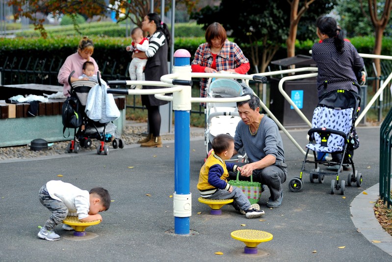 FILE PHOTO: People play with children at a park in Jinhua, Zhejiang province