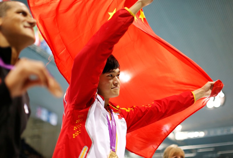 FILE PHOTO: China's Sun Yang celebrates with his gold medal and national flag after winning the men's 1500m freestyle final during the London 2012 Olympic Games at the Aquatics Centre