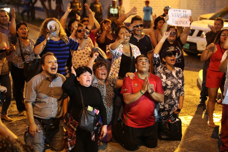 Supporters of former President Alberto Fujimori yell slogans outside hospital where he was hospitalized after a judge annulled a presidential pardon he had been granted in Lima