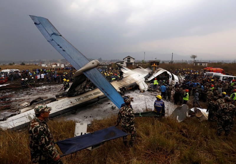 FILE PHOTO - Rescue workers work at the wreckage of a US-Bangla airplane after it crashed at the Tribhuvan International Airport in Kathmandu