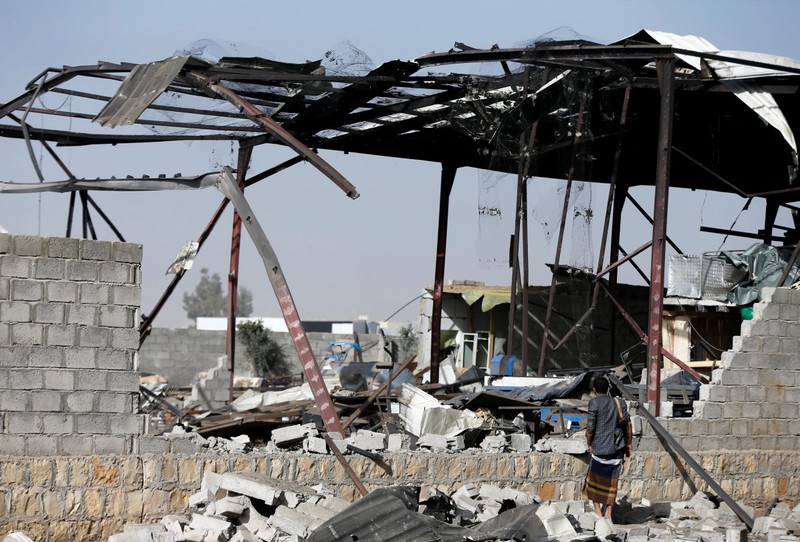 Guard inspects damage at a factory hit by a Saudi-led air strike in Sanaa