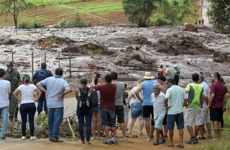 Residents are seen on a road blocked after a dam, owned by Brazilian miner Vale SA, burst in Brumadinho