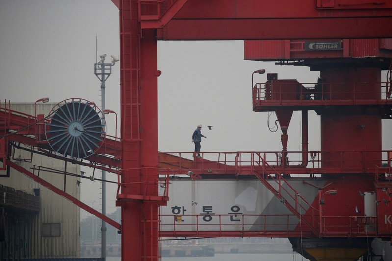 An employee walks on a crane at a container terminal at Incheon port in Incheon