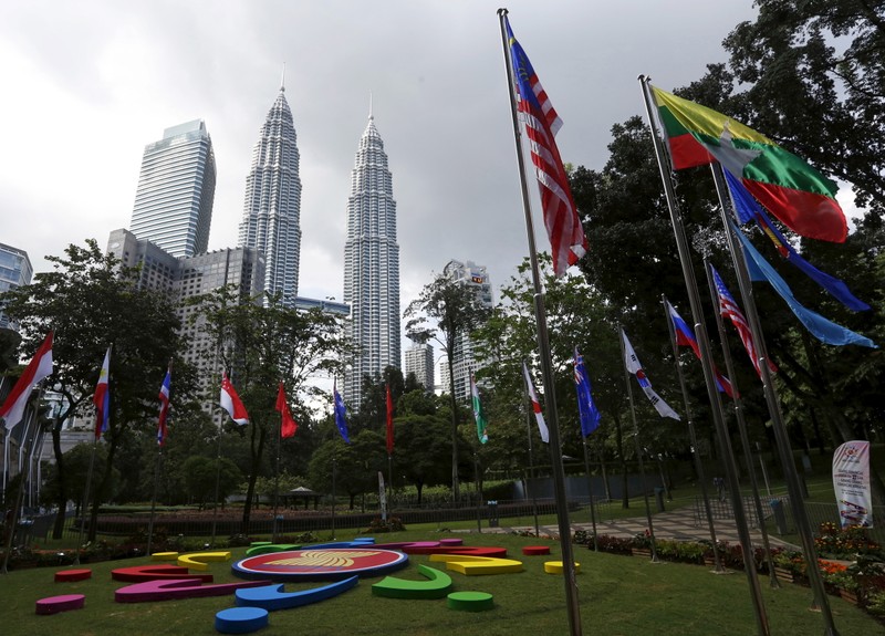 FILE PHOTO: National flags and the ASEAN logo on display ahead of the 27th ASEAN summit in Kuala Lumpur, Malaysia