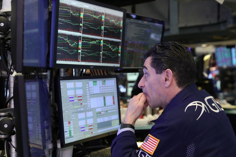 A trader looks at price monitors as he works on the floor at the New York Stock Exchange (NYSE) in New York City, New York