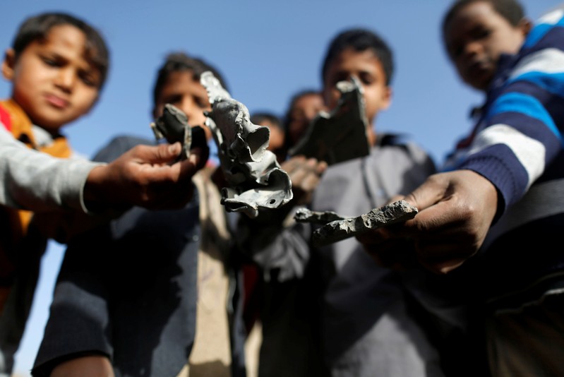 Boys hold missile shrapnel they collected from the site of a Saudi-led air strike in Sanaa