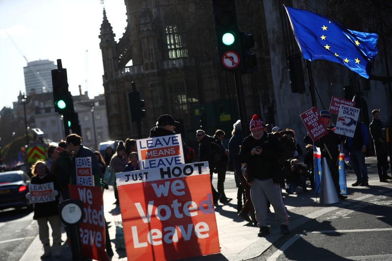 Pro-Brexit and anti-Brexit protesters stand together during a demonstration outside the Houses of Parliament in London