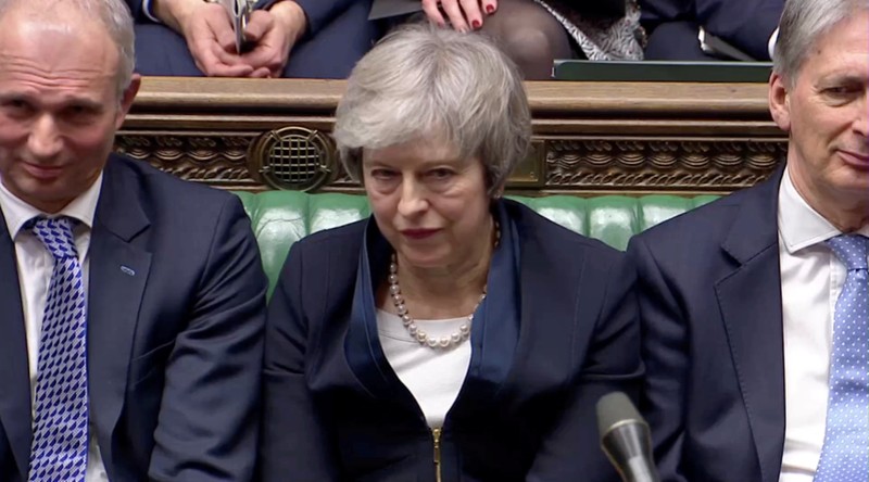 Prime Minister Theresa May sits down in Parliament after the vote on May's Brexit deal, in London