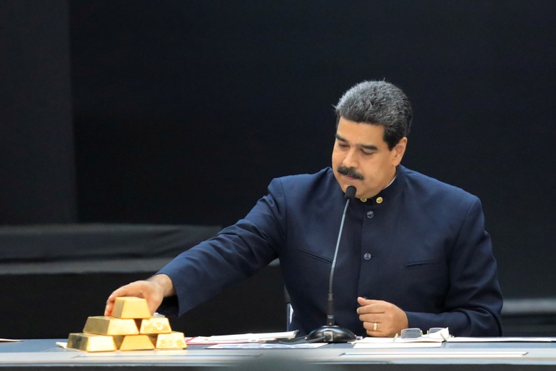 FILE PHOTO: Venezuela's President Nicolas Maduro touches a gold bar as he speaks during a meeting with the ministers responsible for the economic sector at Miraflores Palace in Caraca