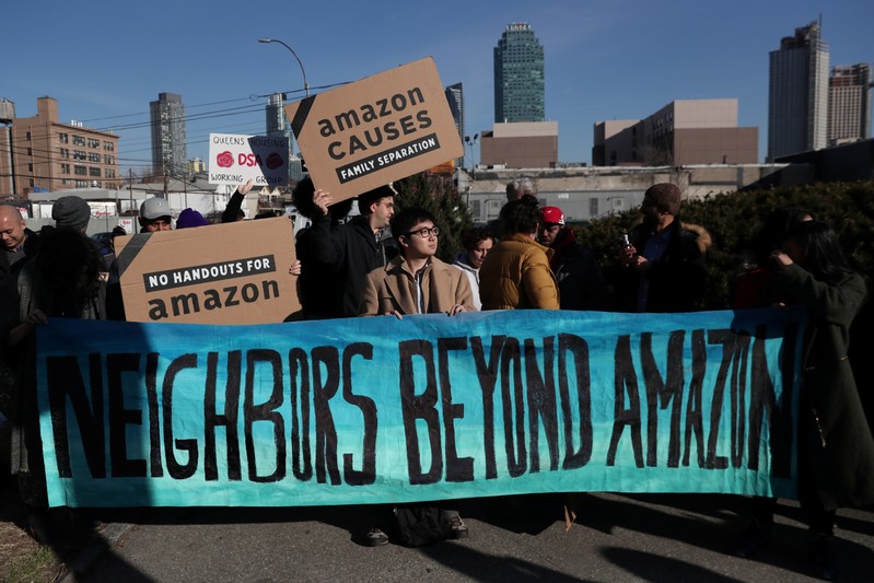 Demonstrators hold signs during a protest against Amazon in the Long Island City section of the Queens borough of New York