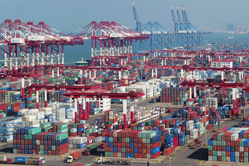 Containers and trucks are seen at a terminal of the Qingdao port in Shandong